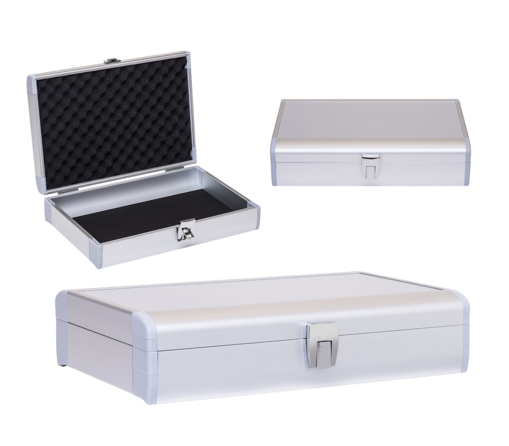 Eine silberne Alu-Boxen-Aufbewahrungsbox wird aus drei Blickwinkeln gezeigt: offen (mit schwarzer Schaumstoffpolsterung im Inneren), geschlossen von vorne und geschlossen aus einem Winkel. Sie ist ideal für B2B-Sonderanfertigungen und verfügt über einen Riegelverschluss, abgerundete Ecken und eine strukturierte Schaumstoffeinlage.