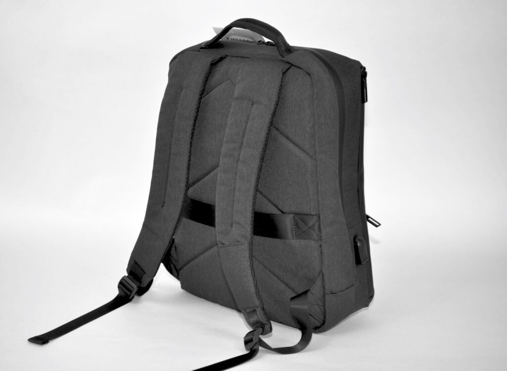 A black rucksack stands on a white background, seen from behind. You can see the padded shoulder straps and the back section as well as a carrying handle at the top and a zipper on the right-hand side - ideal for B2B professionals looking for alternatives to aluminum cases.