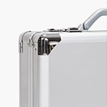 Close-up of the top corners of a silver metal briefcase with chrome reinforcements and a handle, set against a plain white background.